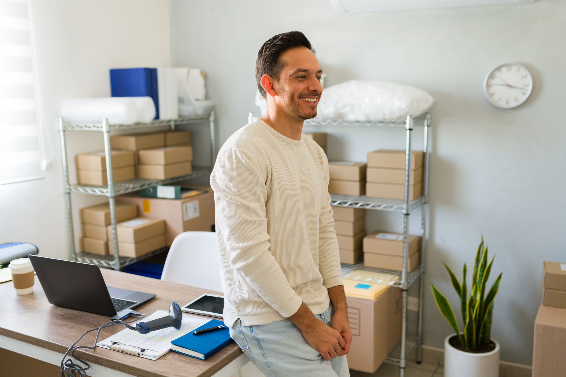 Proud latin entrepreneur running a successful home-based ecommerce business, happily managing packages from his office
